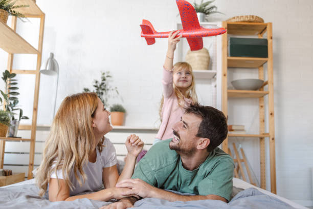 istock Parents playing with daughter in bed 1905214848