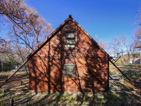 Sustainable architecture with greenhouses and orchards. Triangular timber facades.