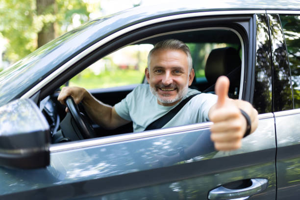 istock Middle age man make selfie by camera doing ok gesture while drive car at street 1905241029