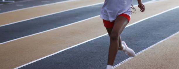 istock Young runner racing on an indoor track 1905248767
