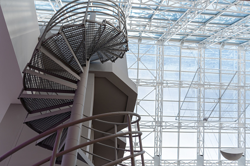 Circular metal staircase, glass ceiling in the background