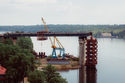 A large architectural structure under construction. Temporary iron piles for the construction of columns. Large industrial equipment.