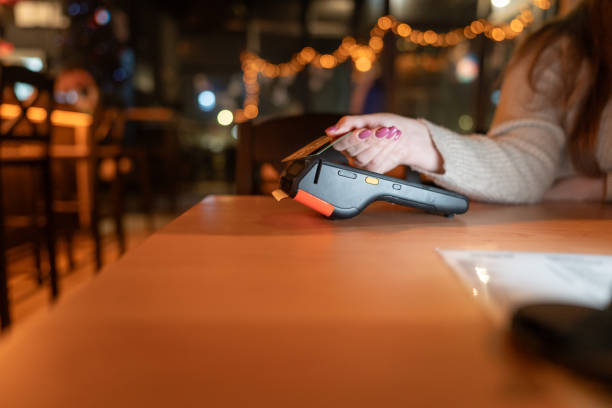 istock Woman paying with credit card at a bar 1905332400