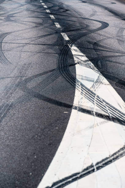 istock Black rubber tire marks in a street.. 1905348360