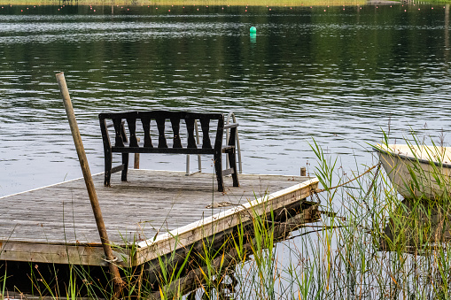 Wooden bench on a floating jetty in a lake.