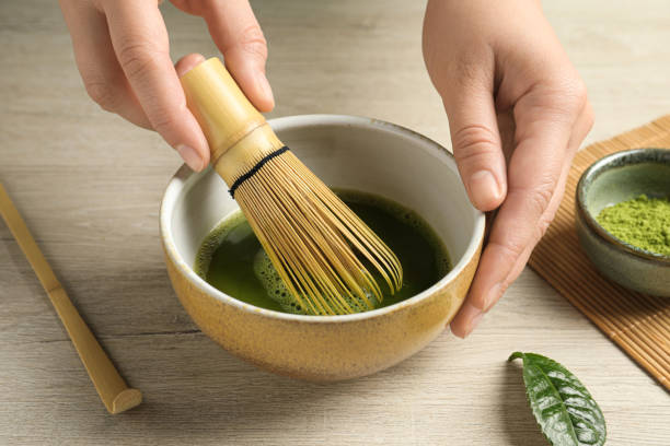istock Woman preparing matcha tea at wooden table, closeup 1905380455