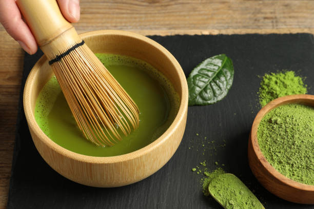 istock Woman preparing matcha tea at wooden table, closeup 1905380962