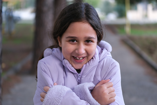 Portrait of a cute little girl shivering in the cold. Happy beautiful girl.