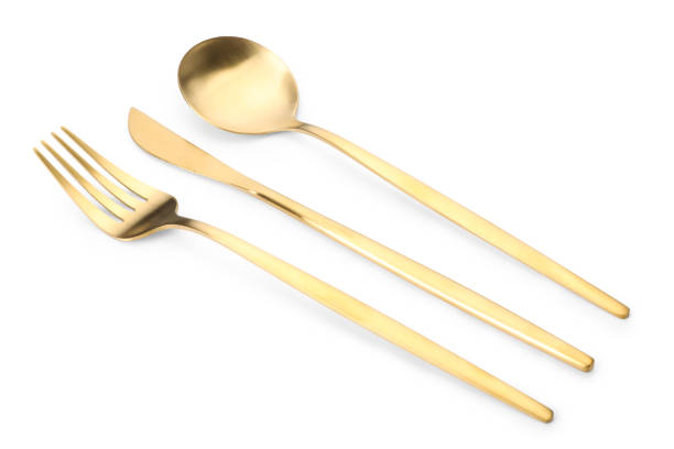 istock Shiny golden fork, knife and spoon isolated on white. Luxury cutlery set 1905413504