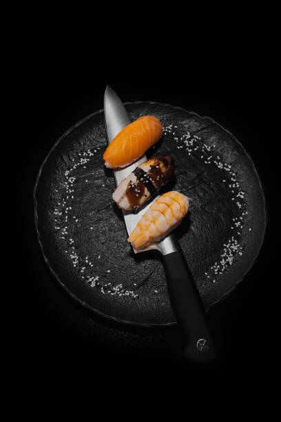 istock Japanese sushi (shrimp, eel, salmon) on a knife 1905430196