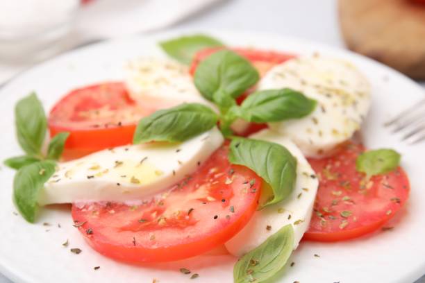 istock Delicious Caprese salad with herbs on plate, closeup 1905450592