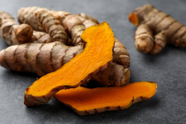 istock Whole and cut turmeric roots on grey table, closeup 1905452185