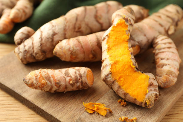 istock Many raw turmeric roots on wooden table, closeup 1905453741