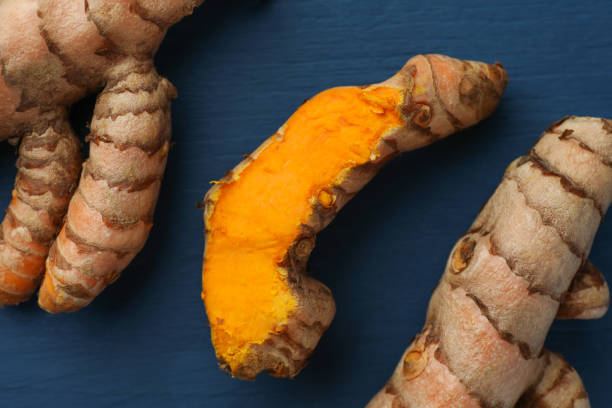istock Raw turmeric roots on blue wooden table, flat lay 1905454792