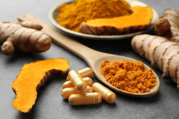istock Aromatic turmeric powder, pills and raw roots on grey table, closeup 1905454796