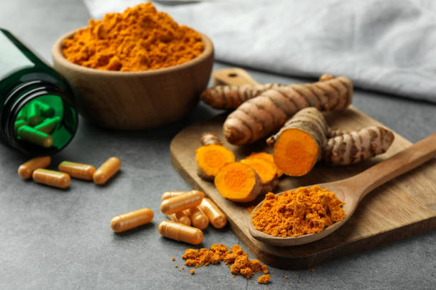 istock Aromatic turmeric powder, pills and raw roots on grey table. Space for text 1905455299