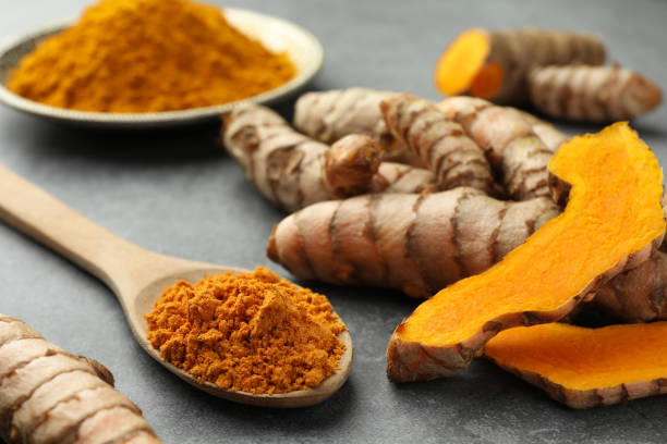 istock Aromatic turmeric powder and raw roots on grey table, closeup 1905455305