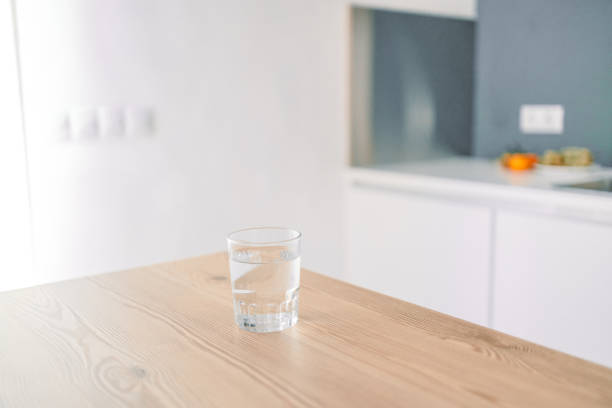 istock Glass of fresh cold water on table in kitchen. Space for text 1905478424
