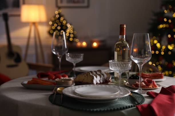 istock Christmas table setting with bottle of wine, appetizers and dishware in room 1905489293