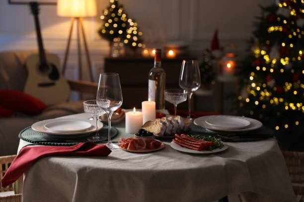 istock Christmas table setting with burning candles, appetizers and dishware in room 1905489800