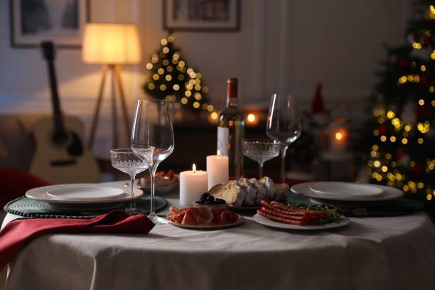 istock Christmas table setting with burning candles, appetizers and dishware in room 1905489803
