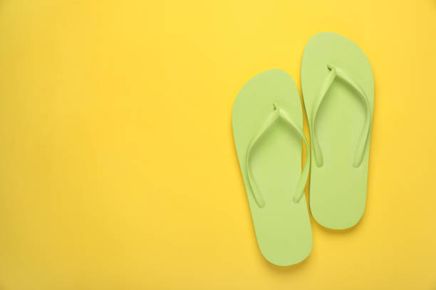 istock Stylish light green flip flops on yellow background, top view. Space for text 1905515658