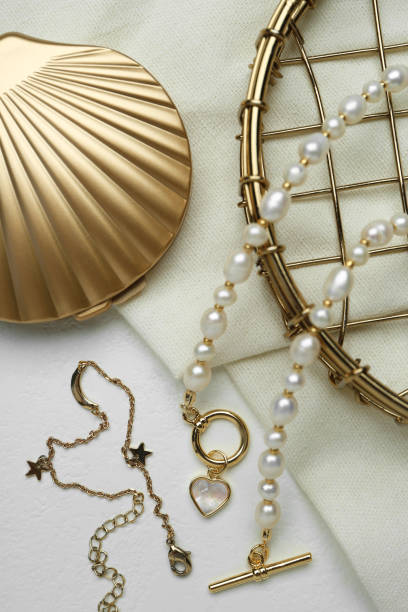 istock Different elegant jewelry and cosmetic pocket mirror on white table, flat lay 1905539946