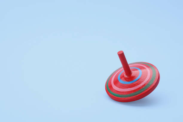 istock One bright spinning top on light blue background, space for text. Toy whirligig 1905541496
