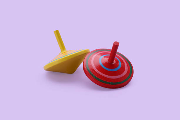 istock Two bright spinning tops on lilac background. Toy whirligig 1905541503