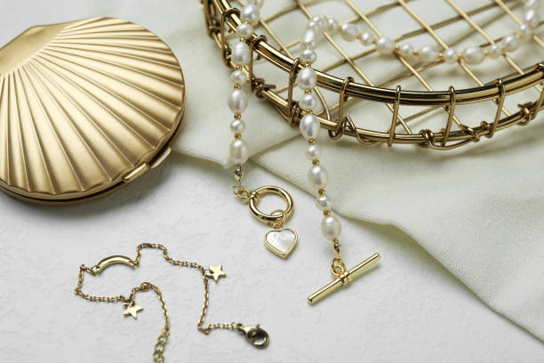 istock Different elegant jewelry and cosmetic pocket mirror on white table, closeup 1905543040