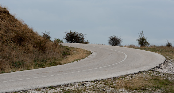 Curved empty asphalt rural mountain road. Cloud sky . Zagori Greece