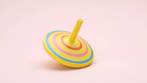 istock One bright spinning top on beige background. Toy whirligig 1905550804