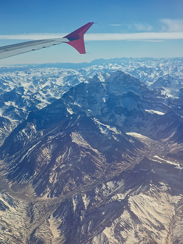 Aerial view of the snow-capped Andes Mountains. View from the window of a plane.