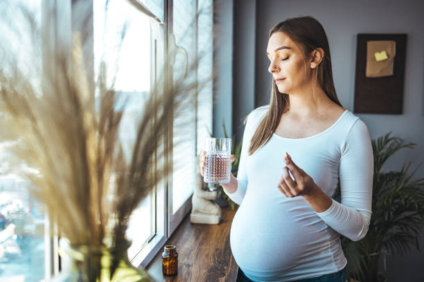 istock Pregnant woman taking pill at home. 1905596238