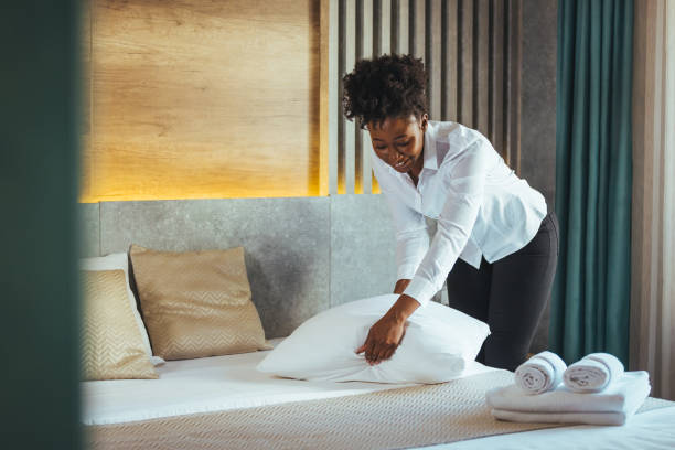 istock Maid making bed in hotel room. 1905616973