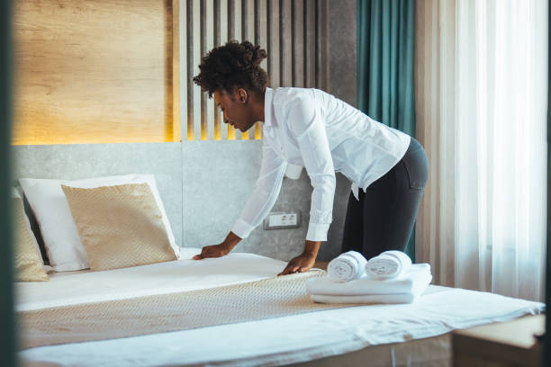 istock Maid making bed in hotel room. 1905617490