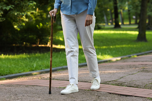 Senior woman with walking cane in park, closeup