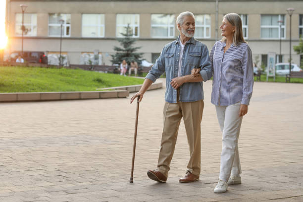 istock Senior man with walking cane and mature woman outdoors. Space for text 1905696507