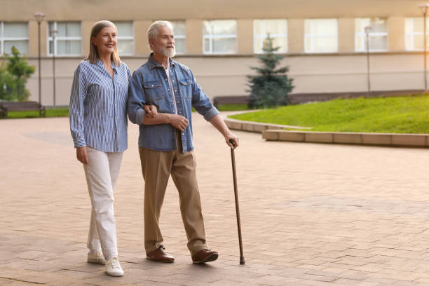 istock Senior man with walking cane and mature woman outdoors. Space for text 1905697016