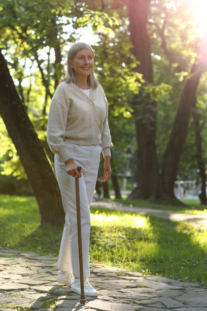 istock Senior woman with walking cane in park 1905697027