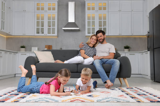 istock Happy couple spending time together while their children drawing on floor at home 1905743501