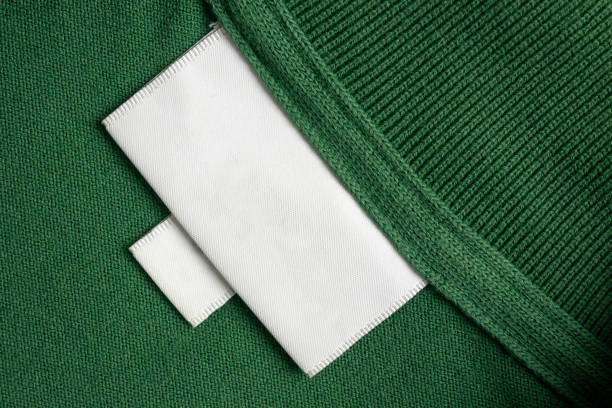 istock Blank white laundry care clothes label on green shirt fabric texture background 1905744610