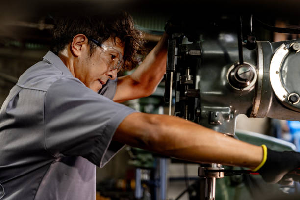 istock Engineer worker in production plant drilling at machine. Professional worker near drilling machine on factory. man inspecting and repairing machine for operation in workshop. 1905756697