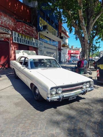 Buenos Aires, Argentina - Nov 6, 2022: Old luxury white 1970s Ford Fairlane GT sedan built in Argentina on the sidewalk at a classic car show.