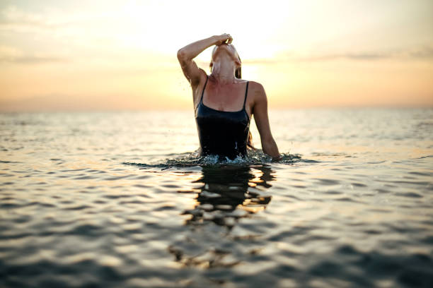 istock Sunset on the beach and a beautiful lady 1905779969