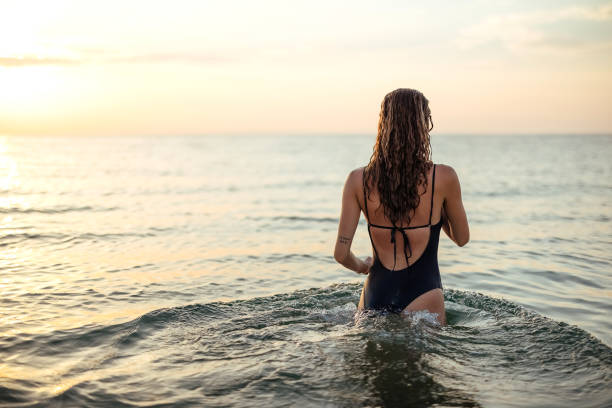 istock Sunset on the beach and a beautiful lady 1905779970