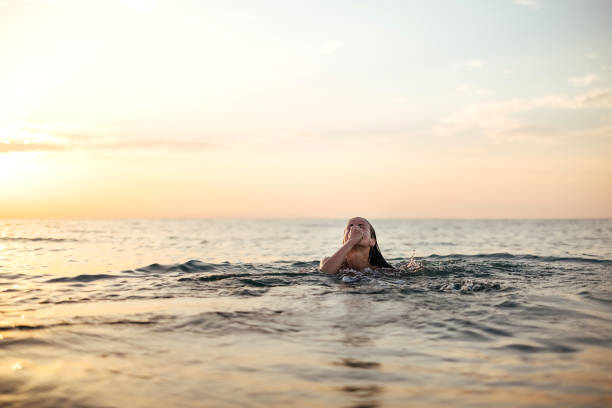 istock Sunset on the beach and a beautiful lady 1905780477