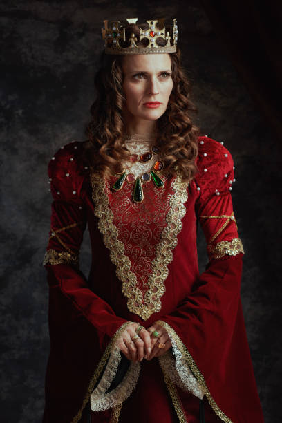 istock medieval queen in red dress with crown 1905831601