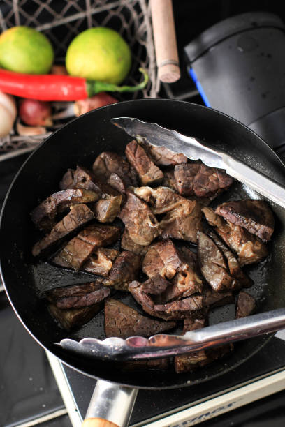 istock Cooking Process Frying Beef Lungs on Black Pan with Less Oil. 1905834697