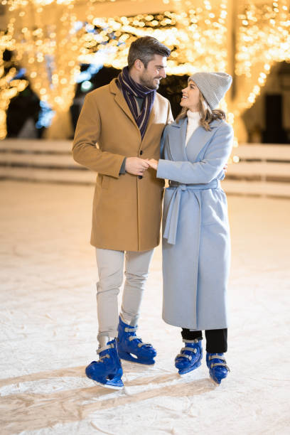 istock Couple on winter holiday ice skating. 1905926101
